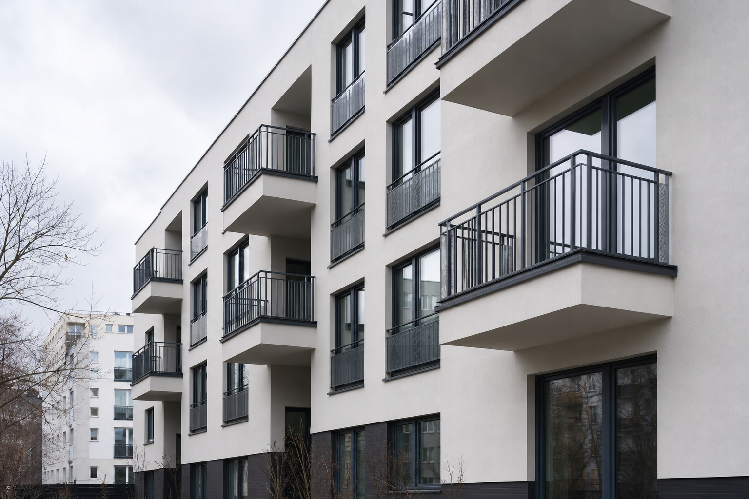 Multi-family building with renewed mineral render facade and balcony railings in Warsaw